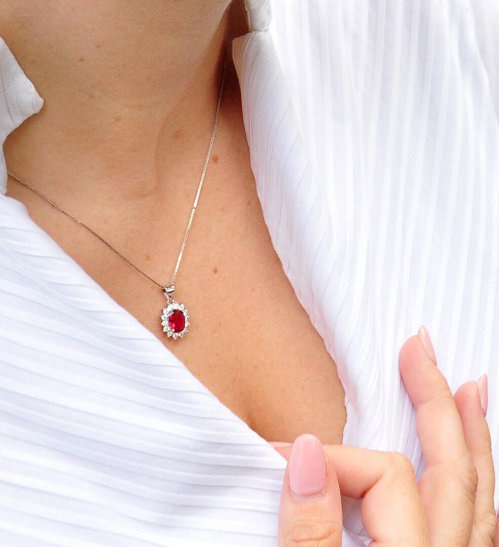 Oval rosette pendant in white sterling silver with chain, with synthetic ruby and white zirconia.